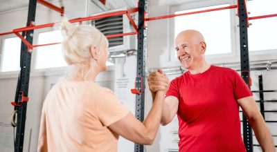 Senior people at the gym giving highfive after training