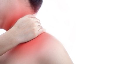 Young woman with neck pain and at white background